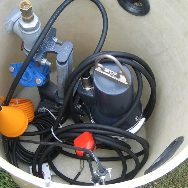 Pompe de relevage submersible avec clapet à bille et flotteurs, sortie de sa cuve pour être remplacée