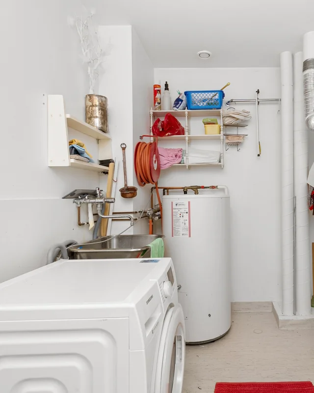 Buanderie en cave avec lave-linge et chauffe-eau