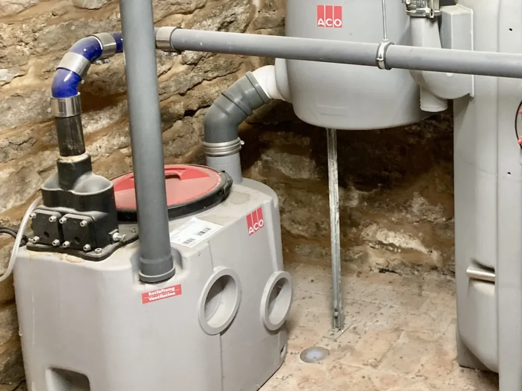 Poste de relevage des eaux usées et ses canalisations dans une cave voûtée