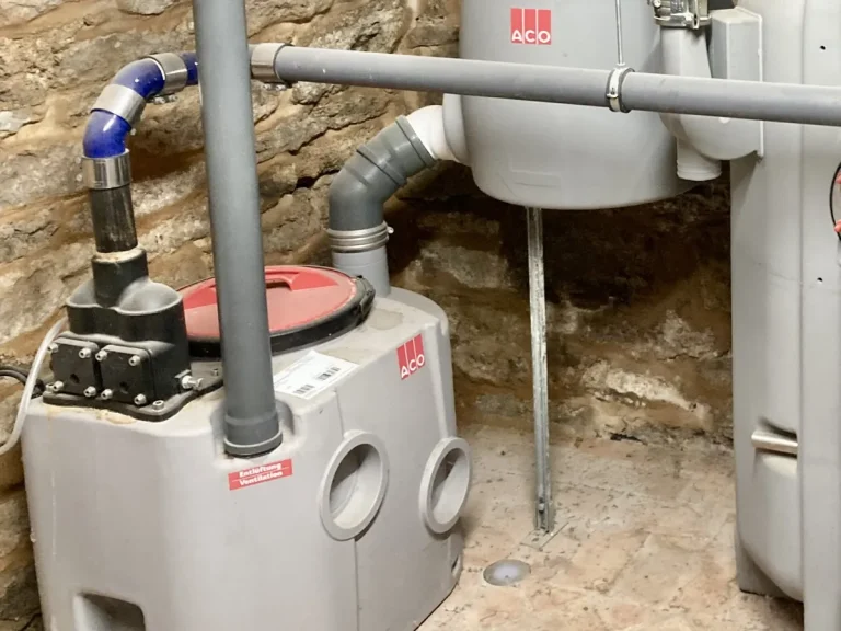 Poste de relevage des eaux usées et ses canalisations dans une cave voûtée